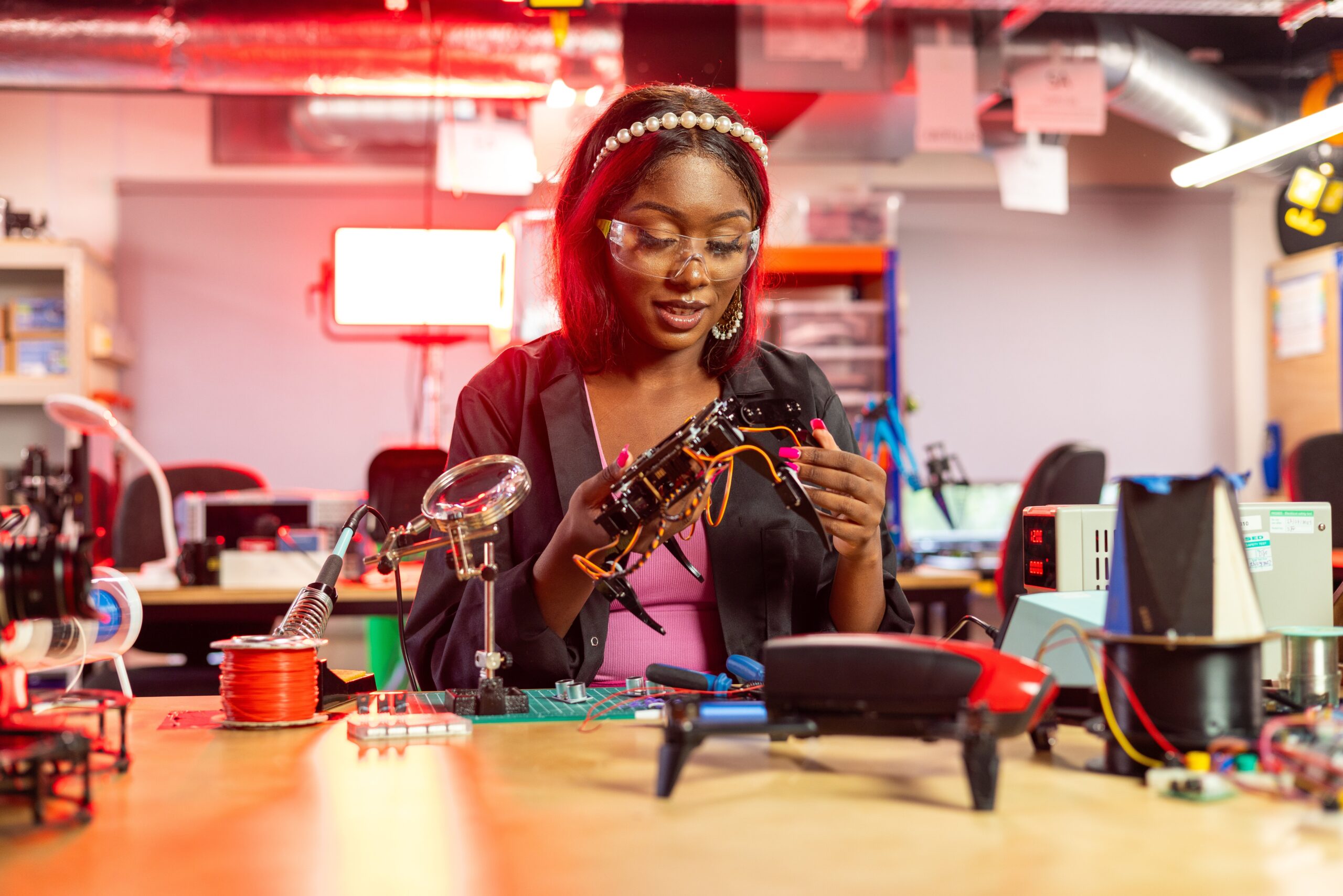 Woman engineer assembling an AI-powered robotic hand in a futuristic technology lab.